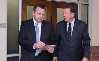 Bob Sexton and Mike Rainwater walking out of a courtroom discussing strategy