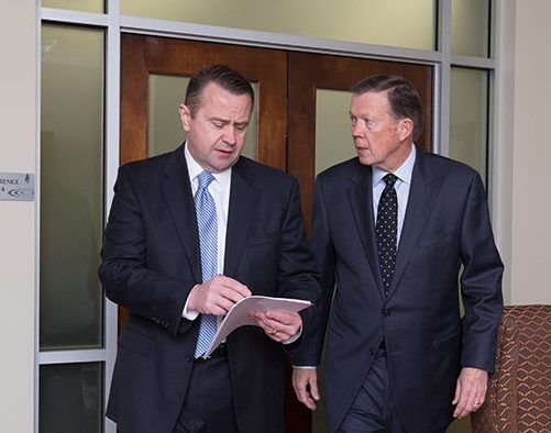 Bob Sexton and Mike Rainwater walking out of a courtroom discussing strategy